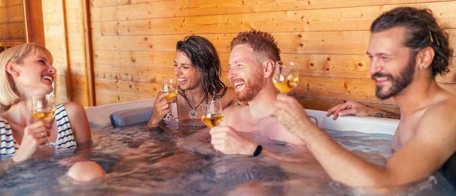 friends-drinking-wine-and-relaxing-in-a-hot-tub